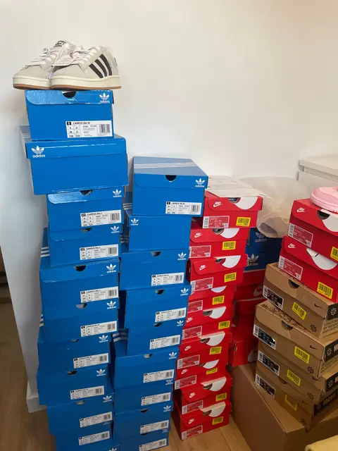 Adidas and Nike boxes stacked floor to shoulder height