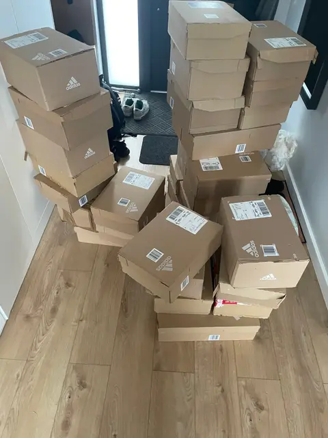 Adidas shipping boxes piled up in a hallway